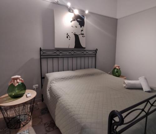 a bedroom with a bed and a table with a lamp at Whiteflower Apartments in Bari