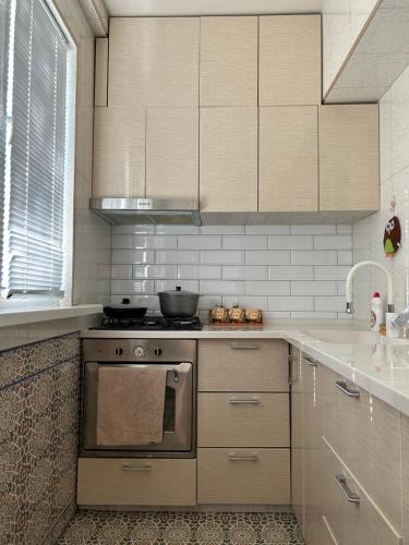 uma cozinha com um fogão de aço inoxidável e armários em 1 Bedroom stylish apartment in TSUM em Tashkent