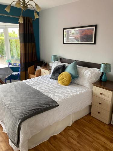 a bedroom with a bed with a yellow pillow on it at Bantry Bay Haven in Ballylickey