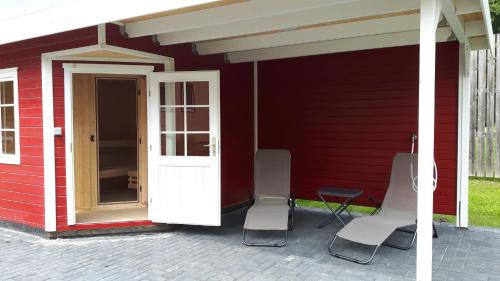 a red house with two chairs and a door at Bode_Apartments in Elend