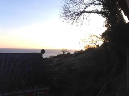 a sunset over the ocean from a house at CHARMING FARM HOUSE IN GUDHJEM in Gudhjem