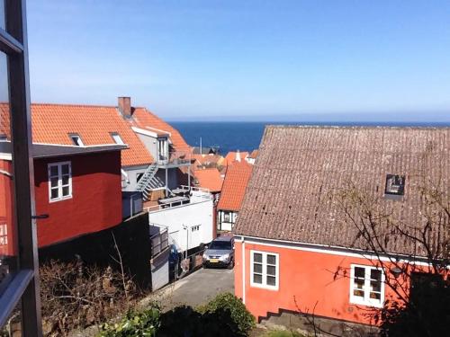 a city with buildings and the ocean in the background at CHARMING FARM HOUSE IN GUDHJEM in Gudhjem