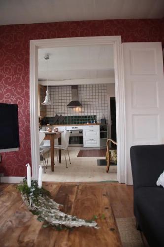 a living room with a table and a kitchen at CHARMING FARM HOUSE IN GUDHJEM in Gudhjem