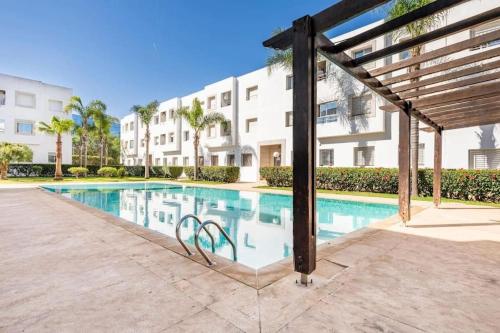 una piscina di fronte a un edificio di Superbe appartement en résidence avec piscine a Skhirat