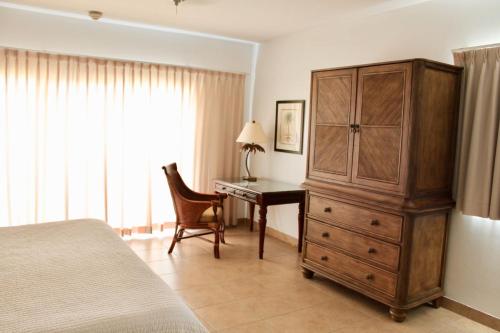 a bedroom with a bed and a desk and a dresser at Bungalows at Windsong on the Reef in The Bight Settlements