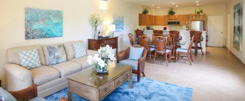 a living room with a couch and a table and a kitchen at Bungalows at Windsong on the Reef in The Bight Settlements