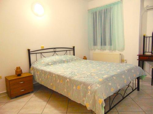 a bedroom with a bed and a dresser and a window at Marilena Apartment, Keremies in Keramiaí