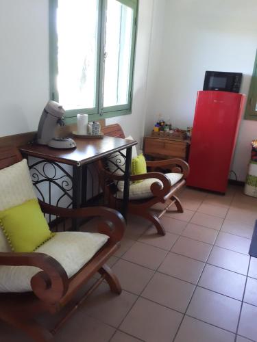 ein Zimmer mit einem Tisch, Stühlen, einem Tisch und einer Küche in der Unterkunft Le Tuléar - Aux 4 coins du monde in Saint-Pierre