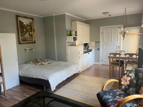 a bedroom with a bed and a kitchen with a table at Villa Verdi in Borgholm