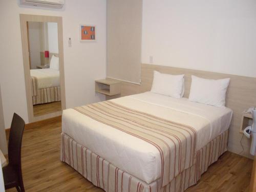 ein Schlafzimmer mit einem großen Bett mit weißer Bettwäsche in der Unterkunft Hotel Rede 1 in Campos dos Goytacazes