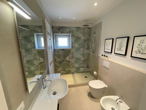 a bathroom with a sink and a toilet and a mirror at San Pietro D'orio Verde in Grado