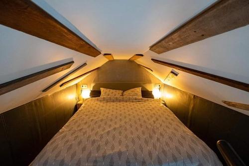 łóżko w małym pokoju z dwoma światłami w obiekcie Autant pour toi w mieście Ciney