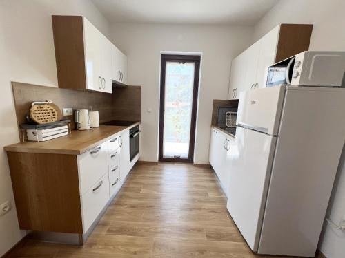 uma cozinha com electrodomésticos brancos e um frigorífico branco em Magnolia Apartments em Izola