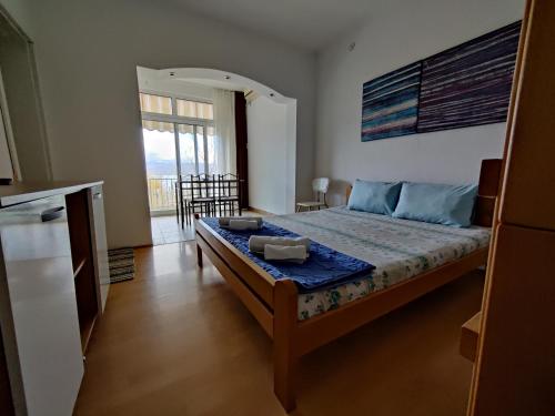a bedroom with a bed and a kitchen with a window at Vila Roza in Star Dojran