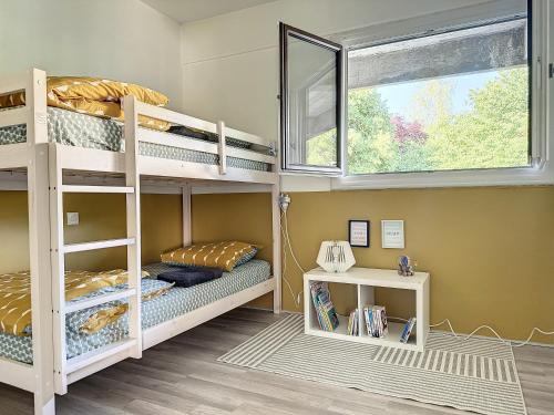 une chambre avec deux lits superposés et une fenêtre dans l'établissement Charmant appartement avec terrasse parking, à Ispagnac
