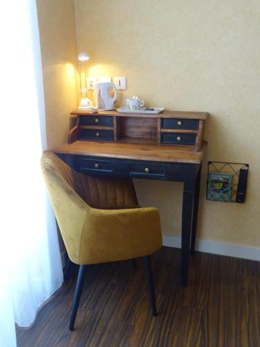 a desk with a chair and a desk with a drawer at LA CROIX D'OR LOGIS Hôtels in Le Faouët