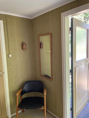 a room with a chair and a mirror on the wall at Cottage with beautiful nature, open landscape, forest and lakes in Tingsryd