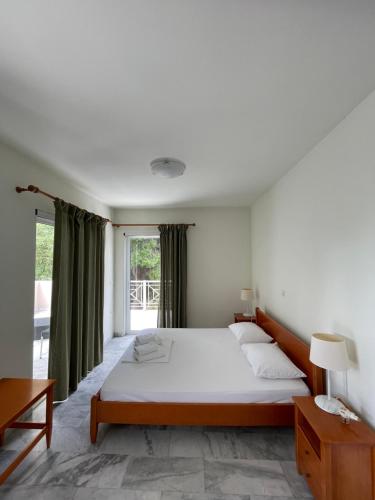 a bedroom with a bed and a large window at Porto Assini in Tolo