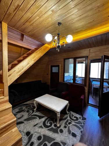 a living room with a couch and a table at Maneviga Cafe & Apart in Uzungol