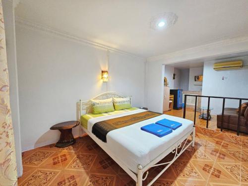 um quarto com uma cama com toalhas azuis em P.California Inter Hostel em Nang Rong