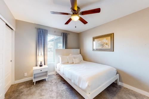 a bedroom with a white bed and a ceiling fan at Pleasant Daydreams in Chandler