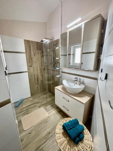 a bathroom with a shower and a sink and a mirror at Moonlight Apartment in Siófok