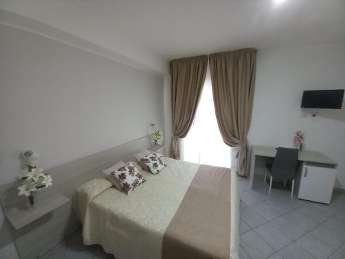 a bedroom with a bed and a desk and a window at Al Giglio - Affittacamere in Cariati