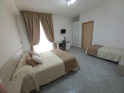 a hotel room with two beds and a window at Al Giglio - Affittacamere in Cariati