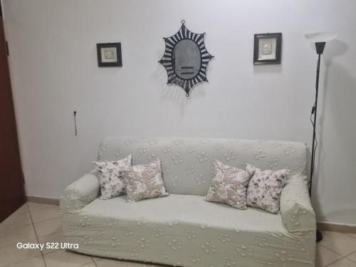 a couch with pillows and a mirror on the wall at Casa vacanze da Nonna Rosa Ortona in Ortona