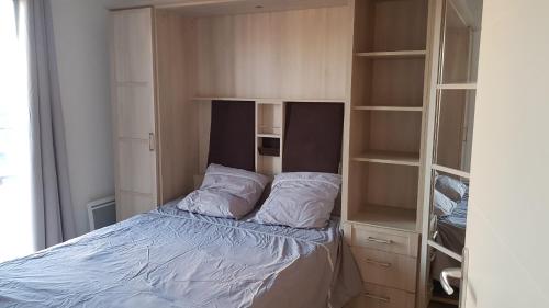 - une petite chambre avec un lit et quelques étagères dans l'établissement T3 Le Lavandou ideally placed 80m² of terraces, au Lavandou