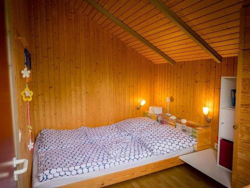 um quarto com uma cama branca numa parede de madeira em Ferienwohnung "Polly" em Glücksburg