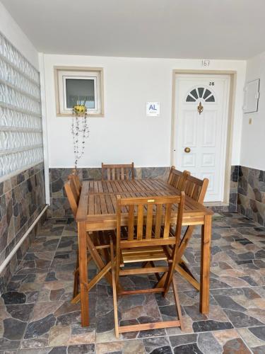 a dining room with a wooden table and chairs at Moradia Gina in Nazaré