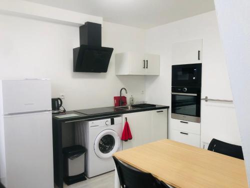 a small kitchen with a washing machine and a washer at LE GITE DE LA GIRAFE CENTRE VILLE LOUVIERS in Louviers