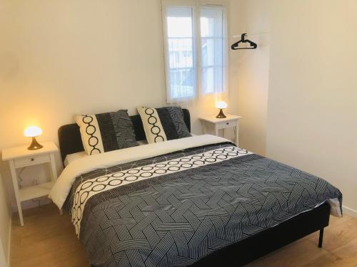 a bedroom with a bed with two night stands and a window at LE GITE DE LA GIRAFE CENTRE VILLE LOUVIERS in Louviers