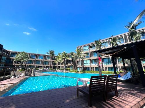 a swimming pool in front of a large building at The Pixels Cape Panwa Condo in Phuket Town