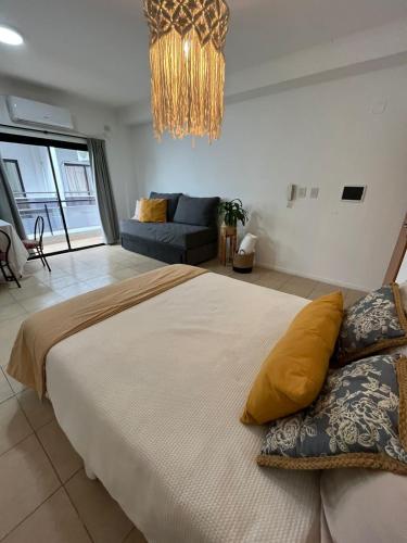 a bedroom with a large bed and a chandelier at Departamento céntrico en Corrientes in Corrientes