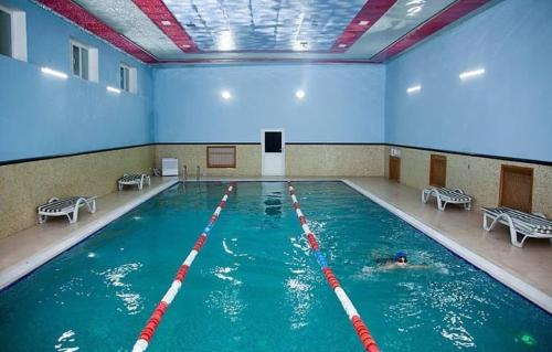 - une piscine avec une personne dans l'eau dans l'établissement Issam Hotel & Spa Sheki, à Shaki