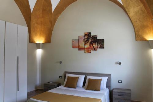 a bedroom with a bed and a painting on the wall at B&B Lizia in Porto Cesareo