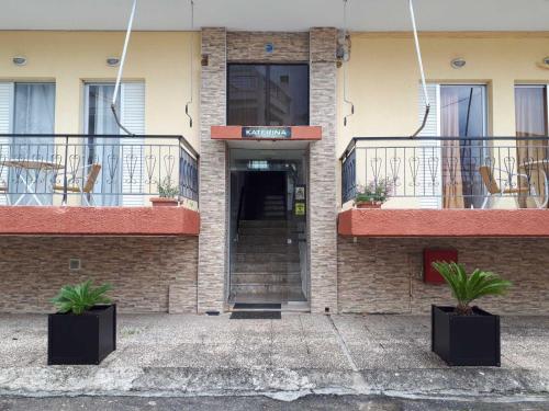 a building with two balconies with tables and chairs at Katerina Apartments in Kalamata