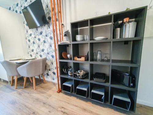 une étagère noire avec une table et une télévision dans l'établissement Studio à 10mn à pied de l'hyper centre, à Albi