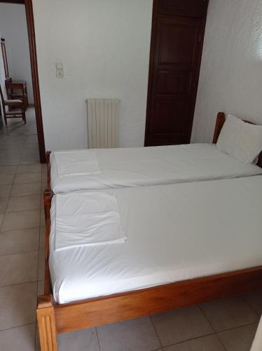 a pair of beds in a room with white sheets at Hotel Apartment Agios Konstantinos in Ágios Konstantínos