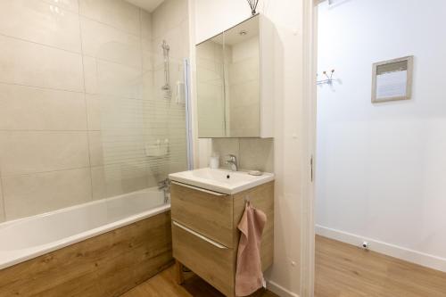 a bathroom with a sink and a shower and a tub at Grand T1 bis de charme tout équipé in Castres