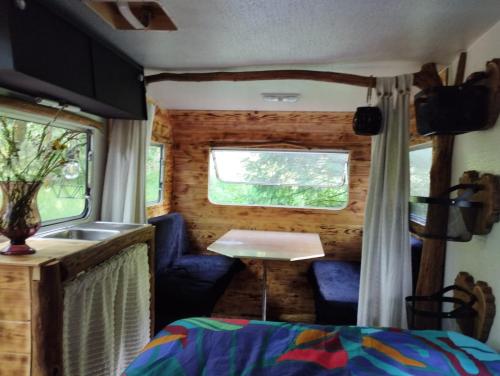 une petite maison avec un évier et une table à l'intérieur dans l'établissement La caravane nature, à Saint-Julien-le-Petit