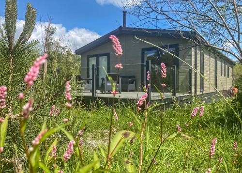 a green tiny house in a field of flowers at Bowland Escapes in Chipping