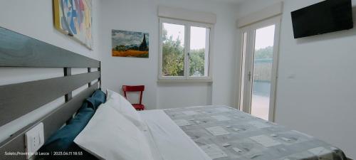 SoletoにあるAlma Casa Vacanzeの白いベッドルーム(ベッド1台、窓付)