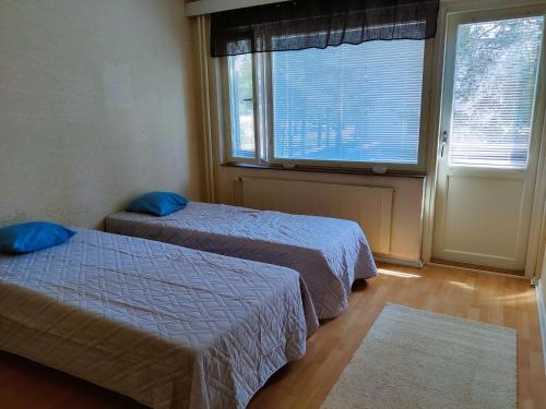 a room with two beds and a large window at Yyterin portti in Pori