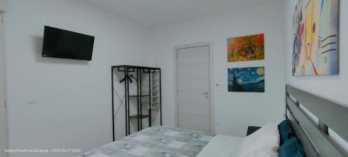 SoletoにあるAlma Casa Vacanzeのベッドルーム1室(ベッド1台、壁掛けテレビ付)