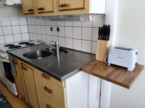 a small kitchen with a sink and a stove at Yyterin portti in Pori