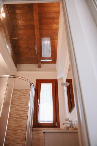 a bathroom with a wooden ceiling and a window at Magnolia Rooms in Civitavecchia