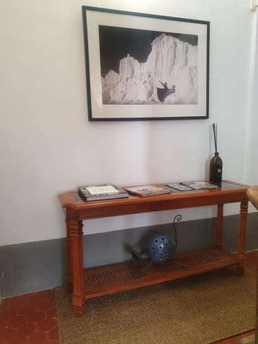 een houten tafel tegen een muur met een schilderij bij Chambre Japonaise baieta in Moulinet